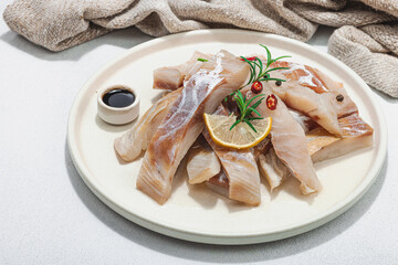 Raw pollock (Pollachius virens) fillet. Fresh fish for healthy food lifestyle. Spices and herbs