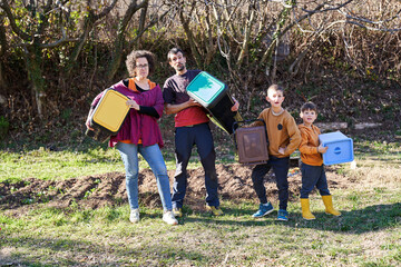 Happy family holding recycling bins. Eco conscientious family concept