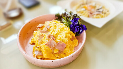 Creamy omelet with ham on rice. Scrambled egg with ham on rice. Rice with ham and soft omelet.