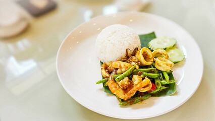 Squid, shrimp, spicy stir-fried on rice. Stir Fried Squid, shrimp with Chilli Paste. Thai Food. Served with vegetables. Seafood served and vegetables and chilli sauce.