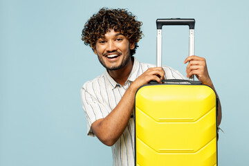 Traveler smiling Indian man he wear white casual clothes hold yellow suitcase bag isolated on plain...