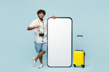 Traveler smiling man wear white casual clothes point on big blank screen mobile cell phone isolated...