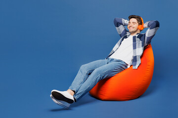 Full body calm happy young man he wearing shirt white t-shirt casual clothes sit in bag chair...