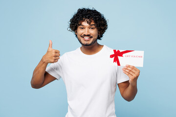 Young happy Indian man he wears white t-shirt casual clothes hold gift certificate coupon voucher...