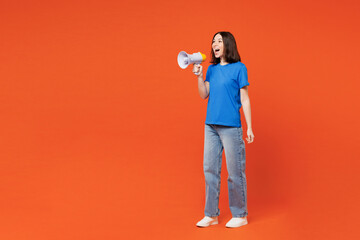 Full body young smiling happy woman wear blue t-shirt casual clothes hold in hand megaphone scream announces discounts sale Hurry up isolated on plain red orange background studio. Lifestyle concept.