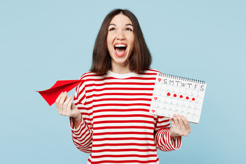 Young fun surprised overjoyed woman wear red casual clothes hold paper airplane female periods pms...