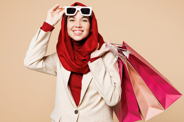 Young Arabian Asian Muslim woman wear red abaya hijab suit clothes shopping hold package bags take...