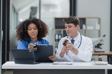 female African American doctor and doctor man working with clipboard in hospital.