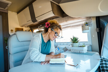 People living off grid traveling with camper van fulltimers vanlife. One woman writing notes inside...