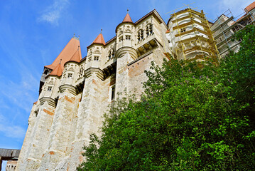 Fototapeta premium Bottom-up view of the medieval gothic Corvin Castle located in the city of Hunedoara in Romania. Beautiful architecture in Transylvania.