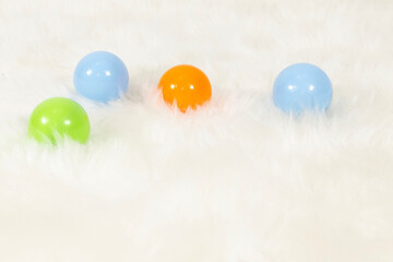 colorful toy balls on white plush carpet