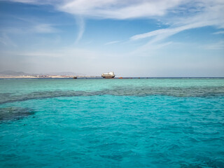 A sunken barge on a coral reef in the Sinai Peninsula in the Red Sea. Sunken ship.