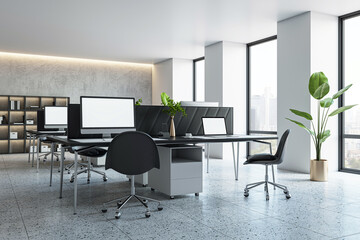 Modern office interior with desks, computers, and large windows, on a city backdrop, conveying a...