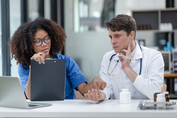 female African American doctor and doctor man working with clipboard in hospital.