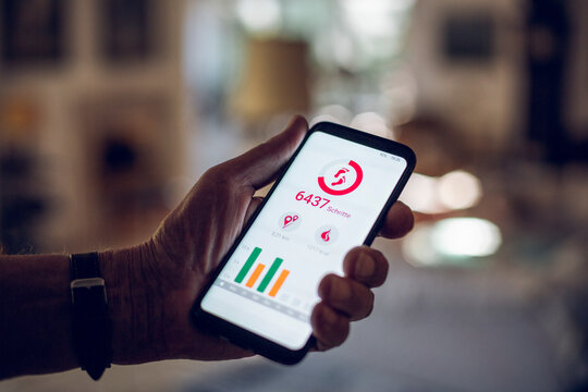 Senior holding smartphone, using fitness app