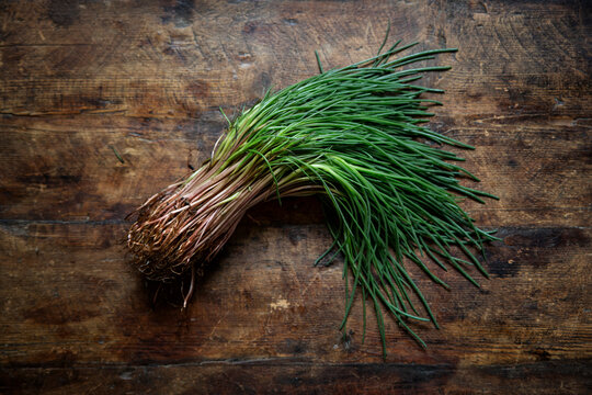 Fresh agretti lying on wooden surface