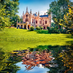 Sturdza castle reflected in the calm waters of small lake. Bright summer scene of the green park in...