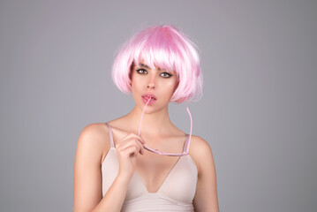 Funny girl with pink wig. Youth and skin care concept. Photo of sensual model isolated on studio background. Close up portrait of beautiful woman with soft clean pure skin. Beauty face of young woman.