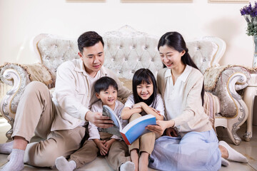 A family of four reading and playing together in the living room