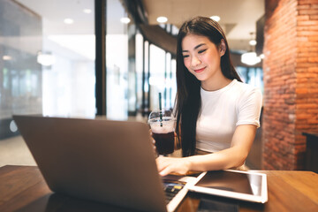 Business freelance asian woman using digital tablet and laptop computer at cafe urban lifestyle