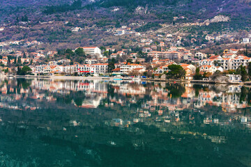 Reflective waterscape of Risan in Kotor Bay, perfect for travel and real estate. Risan, Bay of Kotor, Montenegro