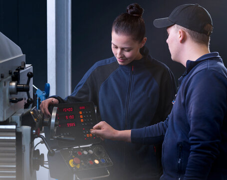 Engineers operating CNC machine at factory