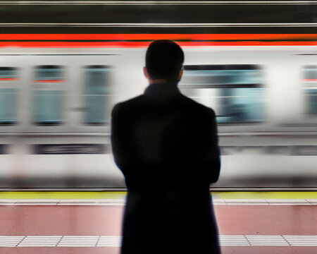 Man standing in front of moving subway train