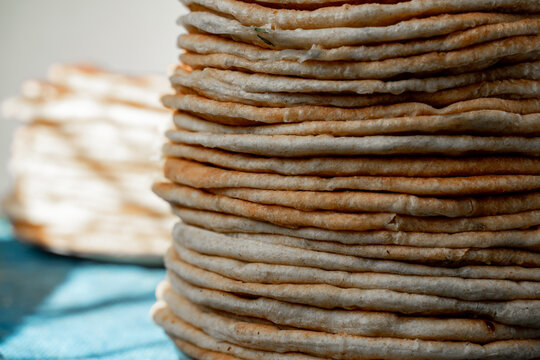 Flatbread lavash, chapati, naan, heap of tortilla on a blue background Homemade flatbread stacked.