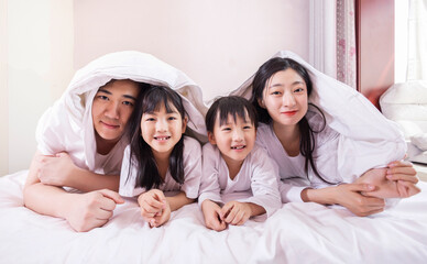 A family of four in bed in the bedroom
