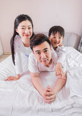 A family of three in the bed in the bedroom