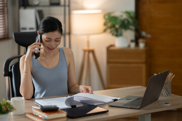 ฺAsia Businesswoman sitting and working using laptop to chat with customers online in office