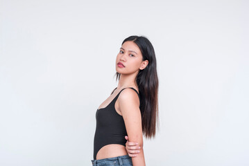 Young Asian woman in stylish black bodysuit posing confidently, isolated on a white background