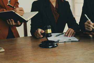 A lawyer prepares for a meeting at their desk, gathering documents and notes. They discuss legal...