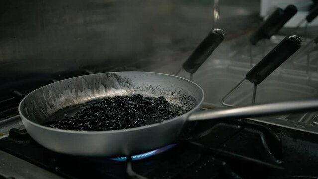 Mixing Black Italian Spaghetti In Pan With Squid Ink Of Restaurant