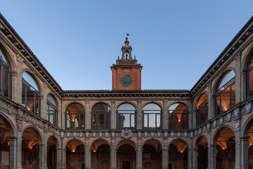 Golden hour light gently kisses the terracotta facade of the University of Bologna, framing the...