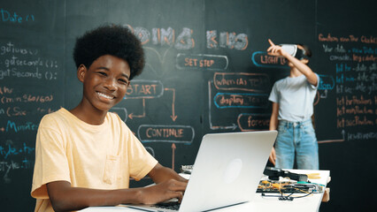 Smart african student programing and coding innovative system while caucasian girl enter in...