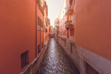 A hidden gem, the Canale delle Moline in Bologna, is framed by terracotta-hued buildings in a photo...