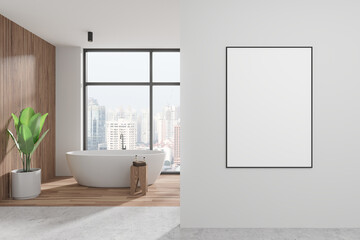 A modern bathroom interior with a freestanding bathtub by a large window, a plant, and a blank poster on the wall, light concept. 3D Rendering