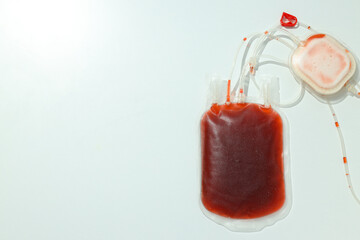 Bag with donated blood on white background, space for text