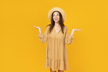 Happy young woman in a hat on yellow background, space for text