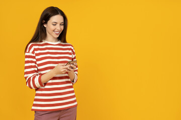 A girl with a phone on a yellow background.