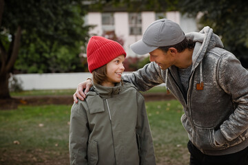 Portrait of happy teenage boy talking to his father and having fun, Joyful bonding: Teenage boy shares laughter and conversation, creating happy moments with his father.