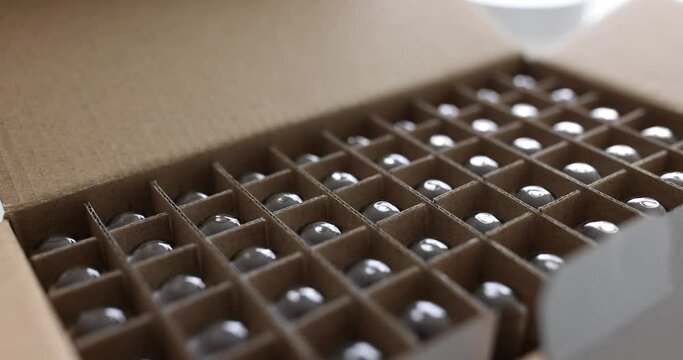 Glass test tubes in open cardboard box in chemical lab premise. New equipment for experiments and researches in laboratory office. Flasks in package