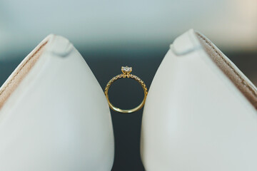 White high heels and an engagement ring with precious stones. Bride's accessories.