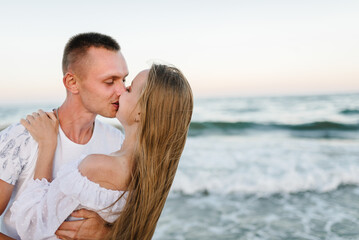 Female kissing and hugging male stand on beach ocean and enjoy sunny summer day on vacation. Woman...