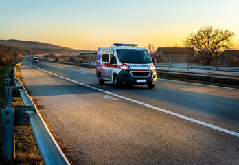 Ambulance van on highway at sunset. Ambulance car responding to the scene of an emergency. - obrazy, fototapety, plakaty