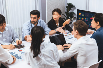 Analyst team utilizing BI Fintech to analyze financial data at table in meeting room....