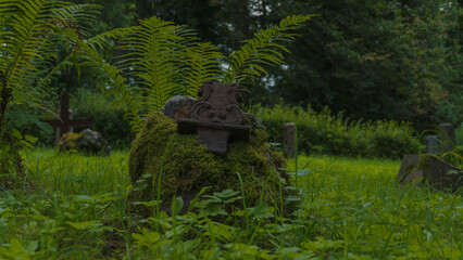 old abandoned piece of metal grave cross with stone