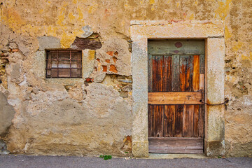 Fototapeta na wymiar Old wooden door and shabby wall in Savosa village, Switzerland