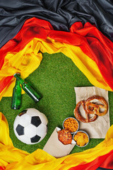 German soccer ball and flag with green grass copy space.